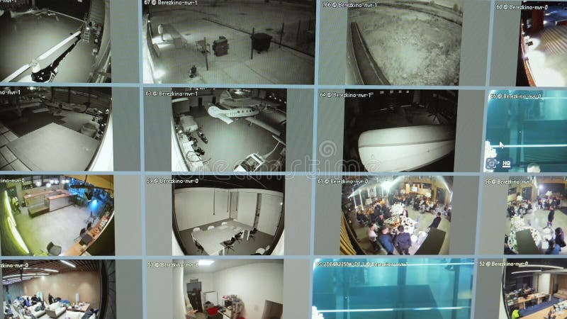 安全监控器显示多个监控摄像头画面，监控停车场、飞机库和办公空间 免版税库存照片