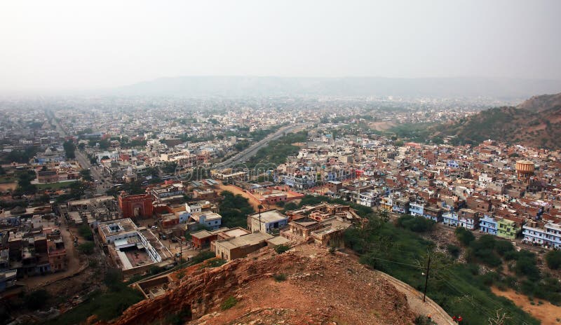 Wide-angle shot overlooking houses and urban sprawl from a hill in Jaipur, India. Smoggy skyline. Wide-angle shot overlooking houses and urban sprawl from a hill in Jaipur, India. Smoggy skyline.