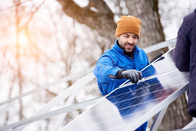 Handsome bearded mature male electrician worker smiling while installing solar pannels on power plant factory copyspace occupation working professionalism confidence job profession environment energy. Handsome bearded mature male electrician worker smiling while installing solar pannels on power plant factory copyspace occupation working professionalism confidence job profession environment energy.