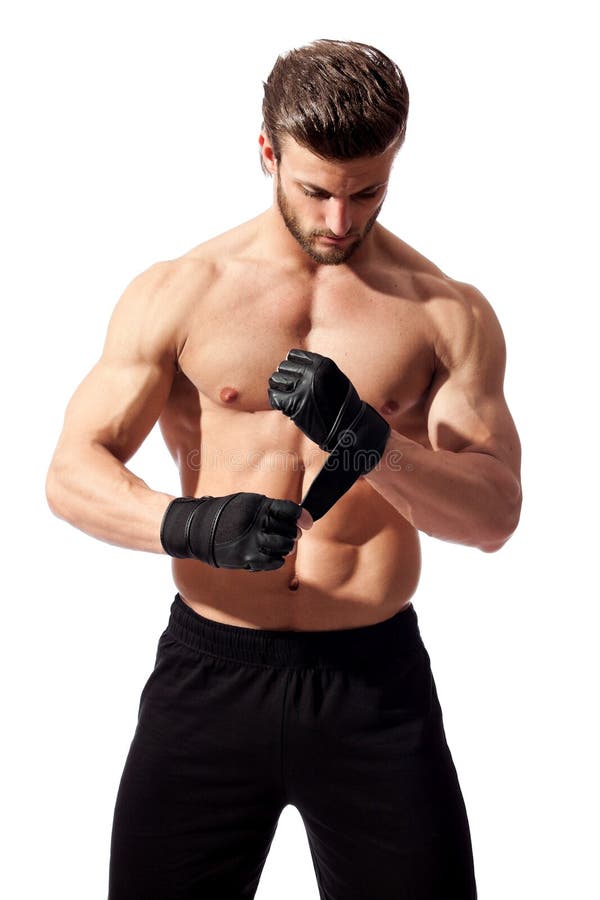 Young fit man putting his gloves, preparing for training. Young fit man putting his gloves, preparing for training