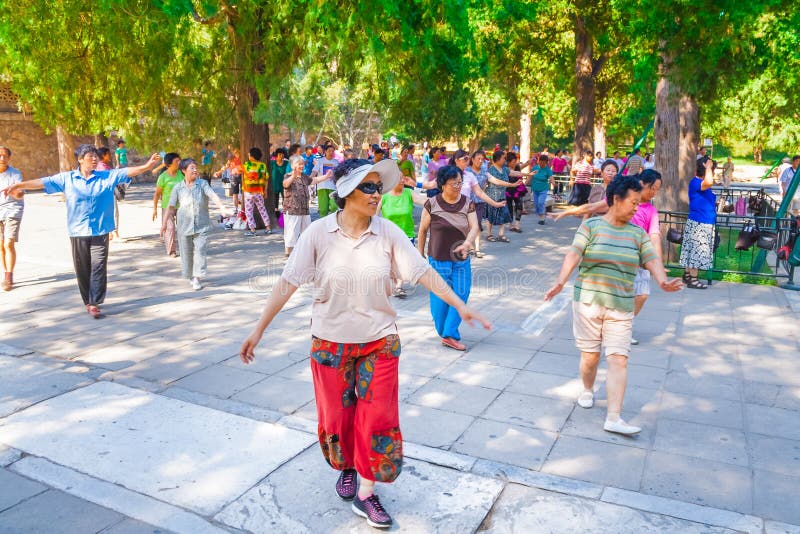实践太极拳的小组更老的亚裔妇女在一个庭院里在北京，中国 免版税库存图片