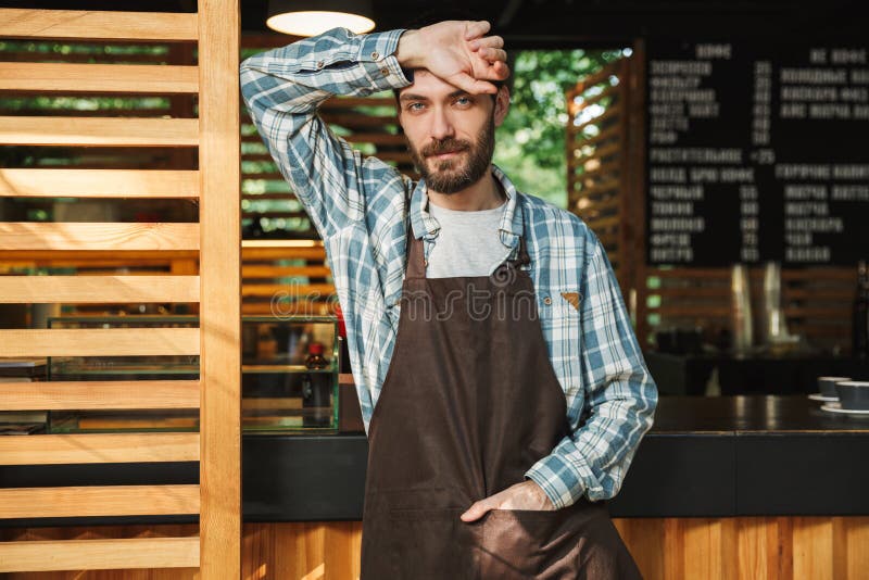 室外英俊的barista人工作在街道咖啡馆的或的咖啡馆画象 库存图片