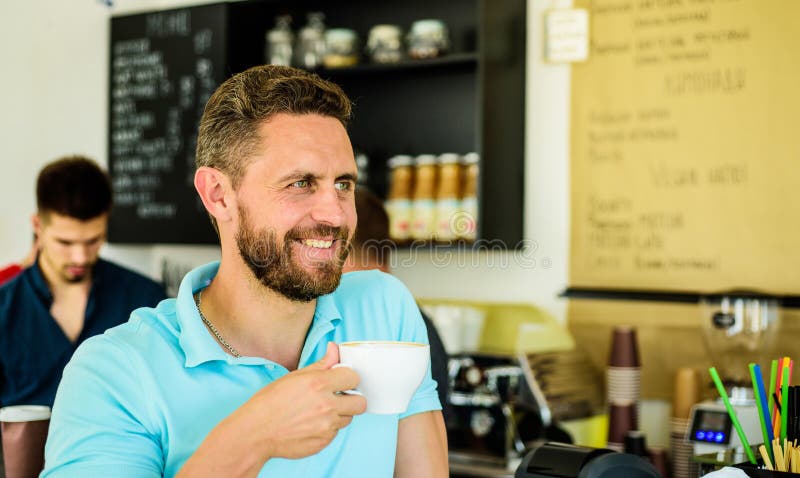 Take moment to care about yourself. Coffee drinkers live longer. Man bearded guy drinks cappuccino cafe background. Cafe visitor happy smiling face enjoy coffee drink. Improve overall health. Take moment to care about yourself. Coffee drinkers live longer. Man bearded guy drinks cappuccino cafe background. Cafe visitor happy smiling face enjoy coffee drink. Improve overall health.