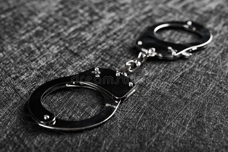 Pair of handcuffs on a dark background. Pair of handcuffs on a dark background