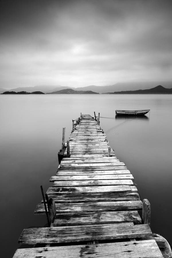 Looking over a desolate peer and a boat, black and white. Looking over a desolate peer and a boat, black and white