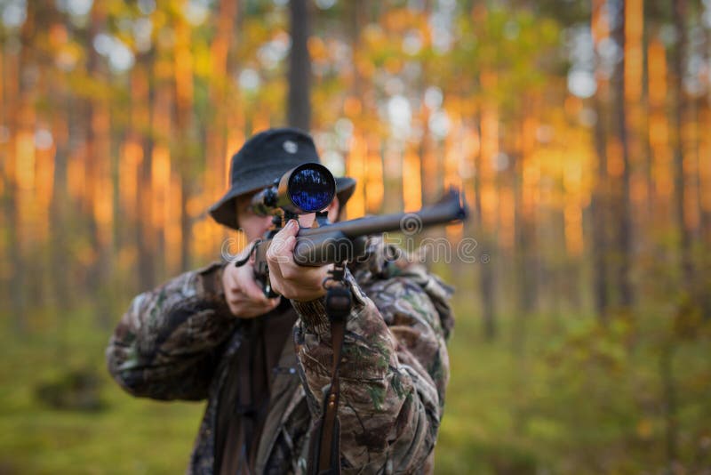Hunter shooting a hunting gun in woods. Hunter shooting a hunting gun in woods