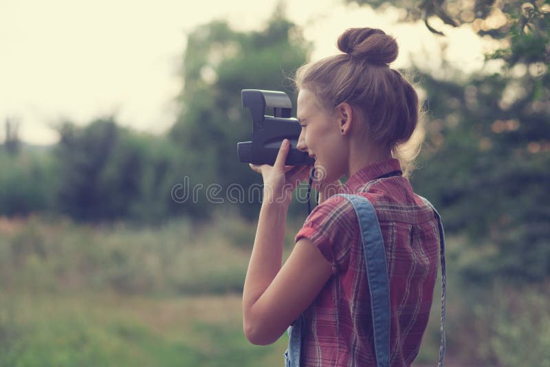 Girl photographer shooting outdoors at sunset. Girl photographer shooting outdoors at sunset