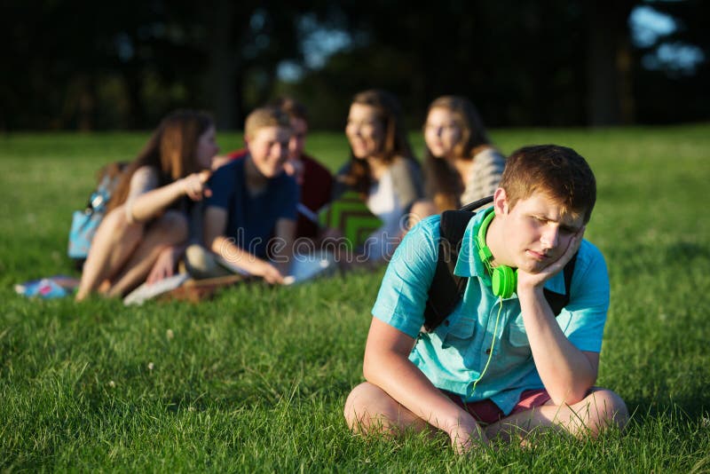 Group of teen bullying sad student sitting outdoors. Group of teen bullying sad student sitting outdoors