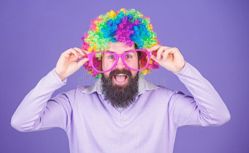 Clown and circus. Party fun. Enjoy being crazy. Feel free to express yourself. Having fun. Holiday fun and carnival concept. Man bearded wear colorful wig and funny glasses on violet background. Clown and circus. Party fun. Enjoy being crazy. Feel free to express yourself. Having fun. Holiday fun and carnival concept. Man bearded wear colorful wig and funny glasses on violet background.