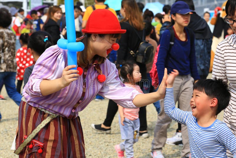 小丑女孩给一高五镇市场的一个小男孩 免版税库存照片 小丑女孩给一高五镇市场的一个小男孩 免版税库存照片