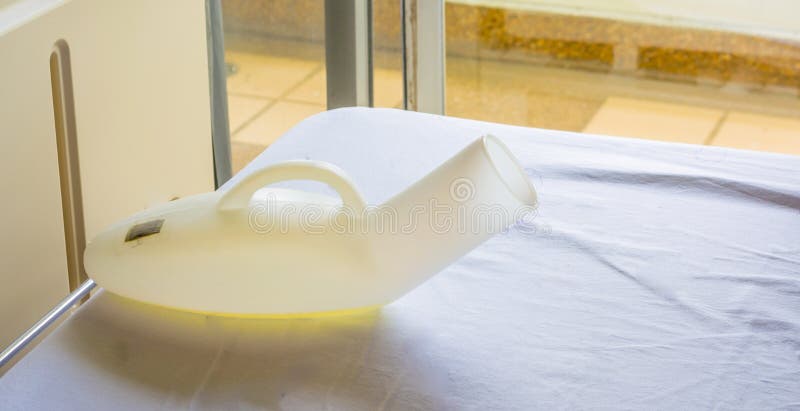 image of pee bottle on hospital's bed . image of pee bottle on hospital's bed .