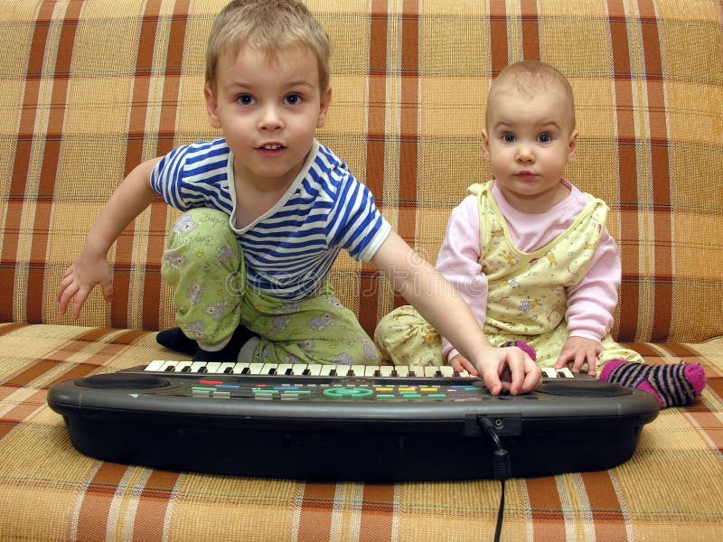 Child and baby play on piano. Child and baby play on piano