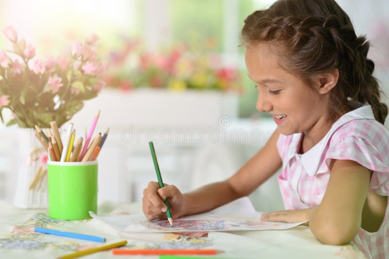 小女孩在家里的桌子上做功课