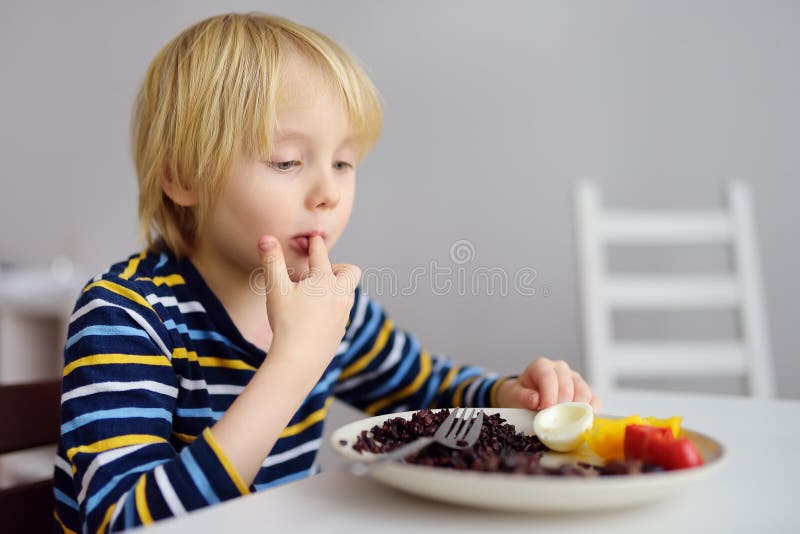 小男孩在厨房吃健康的晚餐 家里美味的食物 库存图片 小男孩在厨房吃健康的晚餐 家里美味的食物 库存图片