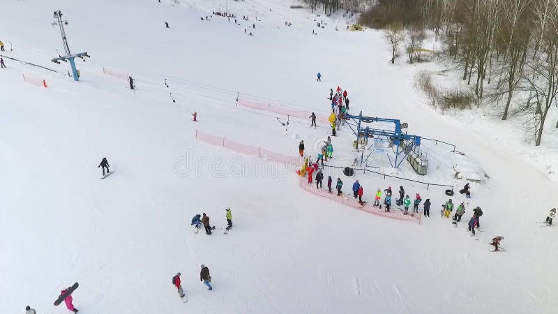 小组天线等待滑雪电缆车的滑雪者和挡雪板乘坐他们多雪的倾斜