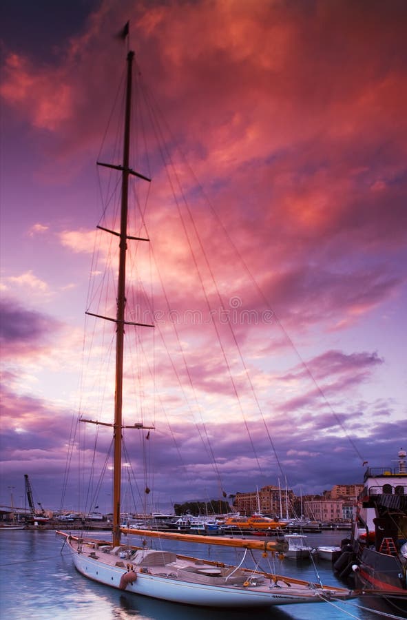 Image shows a moored sailing boat under a dramatic sunset sky. Pictured captured in Cannes, France. Image shows a moored sailing boat under a dramatic sunset sky. Pictured captured in Cannes, France