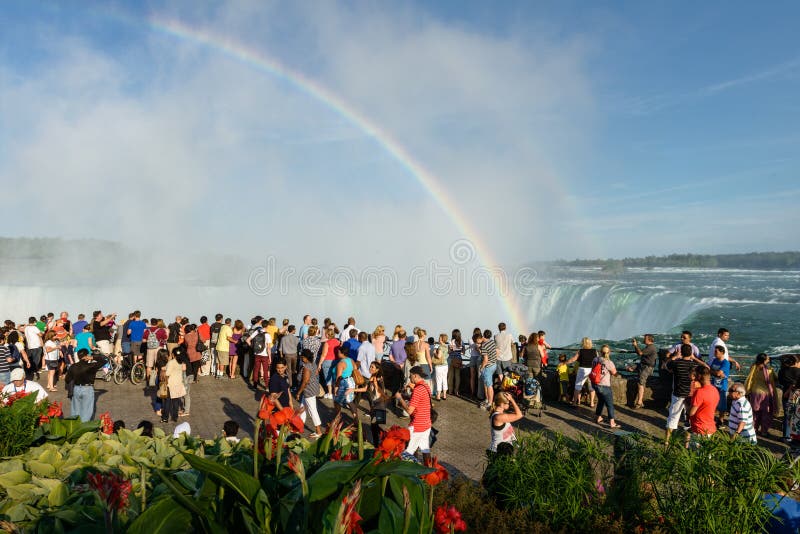 canada niagara September 01-2012 tourists admiring Niagara Falls and rises above the heads rainbow. canada niagara September 01-2012 tourists admiring Niagara Falls and rises above the heads rainbow