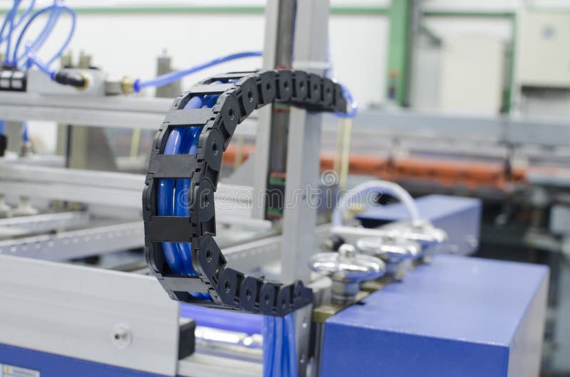 Industrial machine flexible power trak wire tray moving mechanism detail, selective focus copyspace background. Industrial machine flexible power trak wire tray moving mechanism detail, selective focus copyspace background