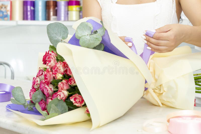 工作在花店的卖花人女孩 新鲜的春天花软的树荫,包裹在装饰纸 Floristry?? 免版税库存图片 工作在花店的卖花人女孩 新鲜的春天花软的树荫,包裹在装饰纸 Floristry?? 免版税库存图片