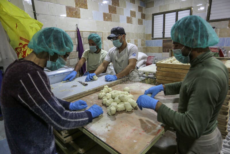 Palestinian workers wearing masks amid coronavirus precautions, bake bread at a bakery, in Rafah in the southern Gaza Strip, on March 10, 2020. Photo by Abed Rahim Khatib. Palestinian workers wearing masks amid coronavirus precautions, bake bread at a bakery, in Rafah in the southern Gaza Strip, on March 10, 2020. Photo by Abed Rahim Khatib