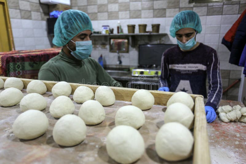 Palestinian workers wearing masks amid coronavirus precautions, bake bread at a bakery, in Rafah in the southern Gaza Strip, on March 10, 2020. Photo by Abed Rahim Khatib. Palestinian workers wearing masks amid coronavirus precautions, bake bread at a bakery, in Rafah in the southern Gaza Strip, on March 10, 2020. Photo by Abed Rahim Khatib