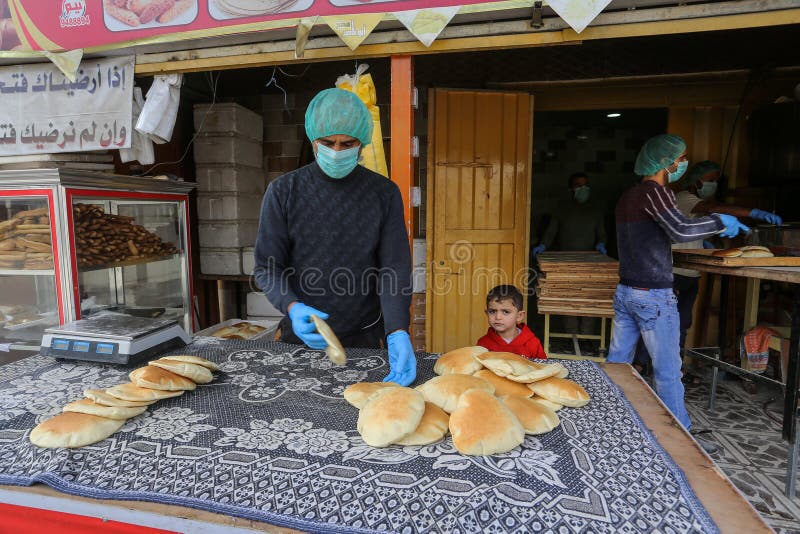 Palestinian workers wearing masks amid coronavirus precautions, bake bread at a bakery, in Rafah in the southern Gaza Strip, on March 10, 2020. Photo by Abed Rahim Khatib. Palestinian workers wearing masks amid coronavirus precautions, bake bread at a bakery, in Rafah in the southern Gaza Strip, on March 10, 2020. Photo by Abed Rahim Khatib