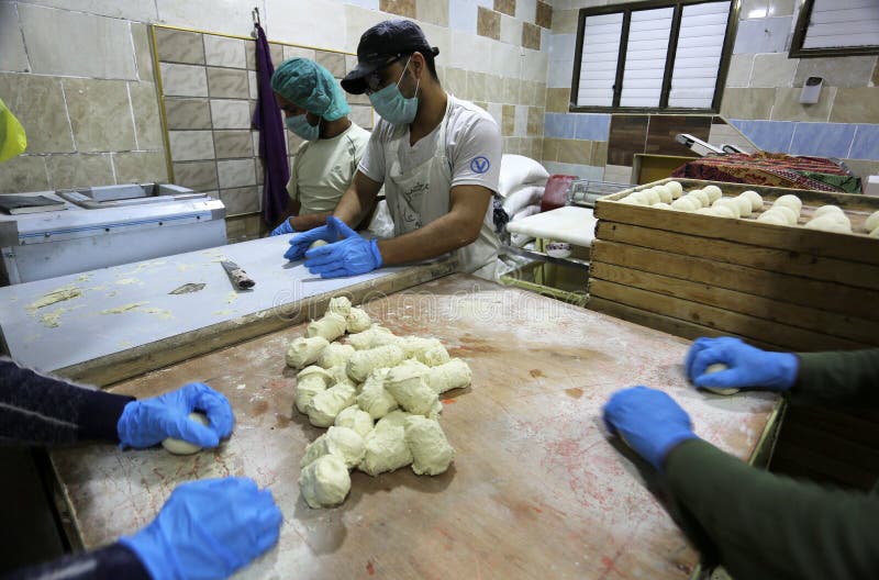 Palestinian workers wearing masks amid coronavirus precautions, bake bread at a bakery, in Rafah in the southern Gaza Strip, on March 10, 2020. Photo by Abed Rahim Khatib. Palestinian workers wearing masks amid coronavirus precautions, bake bread at a bakery, in Rafah in the southern Gaza Strip, on March 10, 2020. Photo by Abed Rahim Khatib