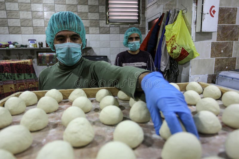 Palestinian workers wearing masks amid coronavirus precautions, bake bread at a bakery, in Rafah in the southern Gaza Strip, on March 10, 2020. Photo by Abed Rahim Khatib. Palestinian workers wearing masks amid coronavirus precautions, bake bread at a bakery, in Rafah in the southern Gaza Strip, on March 10, 2020. Photo by Abed Rahim Khatib