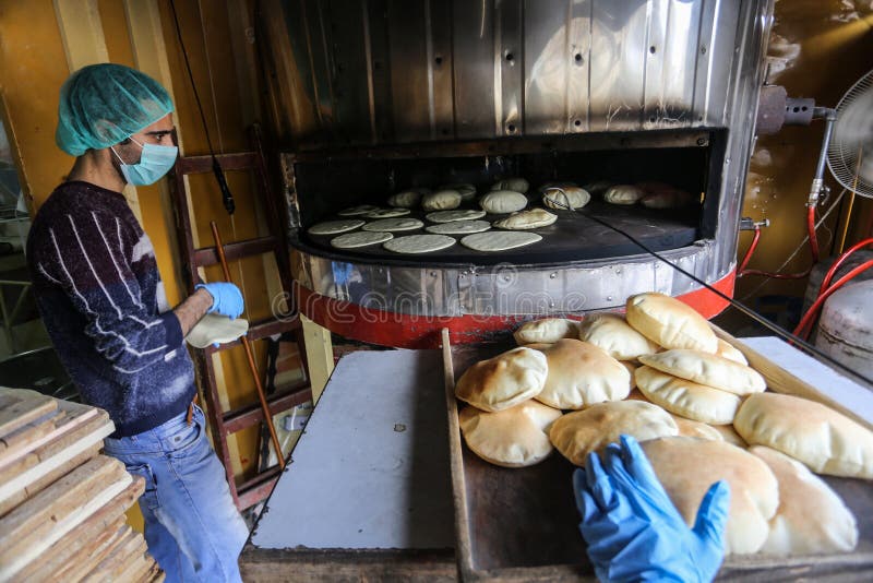 Palestinian workers wearing masks amid coronavirus precautions, bake bread at a bakery, in Rafah in the southern Gaza Strip, on March 10, 2020. Photo by Abed Rahim Khatib. Palestinian workers wearing masks amid coronavirus precautions, bake bread at a bakery, in Rafah in the southern Gaza Strip, on March 10, 2020. Photo by Abed Rahim Khatib