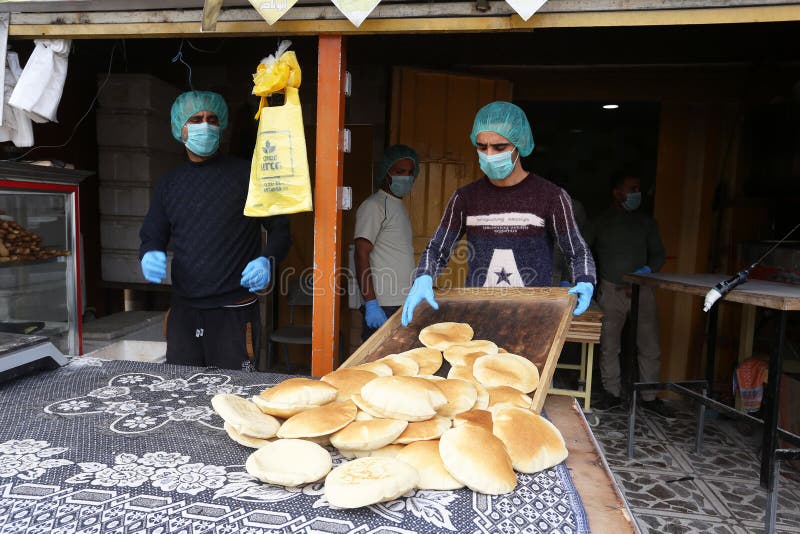 Palestinian workers wearing masks amid coronavirus precautions, bake bread at a bakery, in Rafah in the southern Gaza Strip, on March 10, 2020. Photo by Abed Rahim Khatib. Palestinian workers wearing masks amid coronavirus precautions, bake bread at a bakery, in Rafah in the southern Gaza Strip, on March 10, 2020. Photo by Abed Rahim Khatib