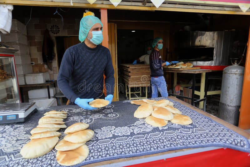 Palestinian workers wearing masks amid coronavirus precautions, bake bread at a bakery, in Rafah in the southern Gaza Strip, on March 10, 2020. Photo by Abed Rahim Khatib. Palestinian workers wearing masks amid coronavirus precautions, bake bread at a bakery, in Rafah in the southern Gaza Strip, on March 10, 2020. Photo by Abed Rahim Khatib