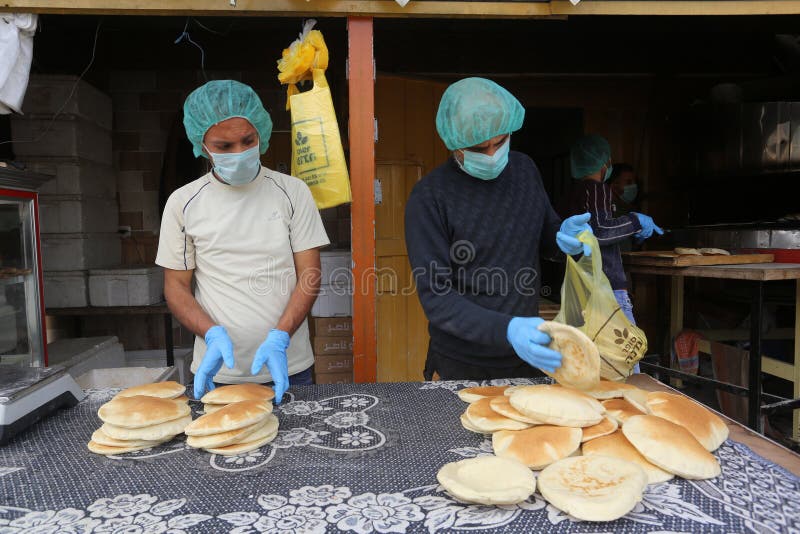 Palestinian workers wearing masks amid coronavirus precautions, bake bread at a bakery, in Rafah in the southern Gaza Strip, on March 10, 2020. Photo by Abed Rahim Khatib. Palestinian workers wearing masks amid coronavirus precautions, bake bread at a bakery, in Rafah in the southern Gaza Strip, on March 10, 2020. Photo by Abed Rahim Khatib