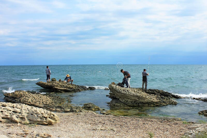 Baku, Azerbaijan, 09.01.2021. Fishermen on the rocks catch fish in the Caspian Sea. Baku, Azerbaijan, 09.01.2021. Fishermen on the rocks catch fish in the Caspian Sea