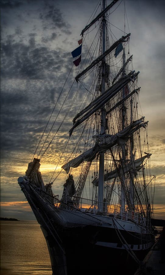 An old sailing ship at dockside at sunset. An old sailing ship at dockside at sunset.