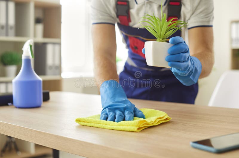 带家用洗涤剂用品的男式清洁擦桌的特写. 免版税库存图片