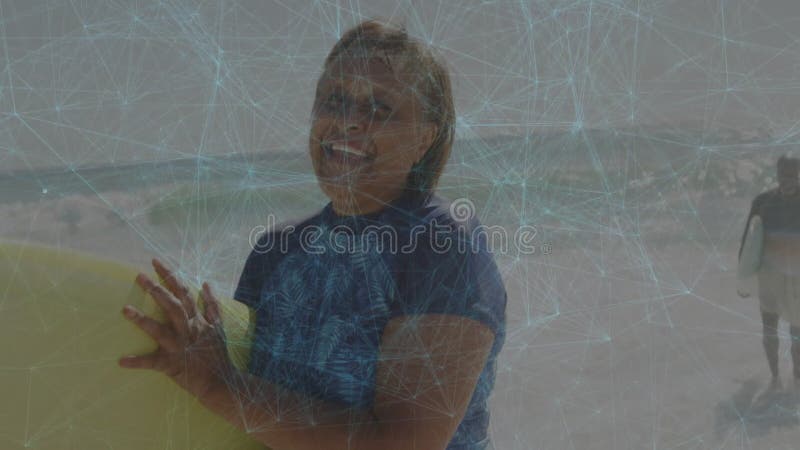 带浮动健康图标覆盖的成年男子冲浪微笑的抓握冲浪板在沙滩上行走 影视素材