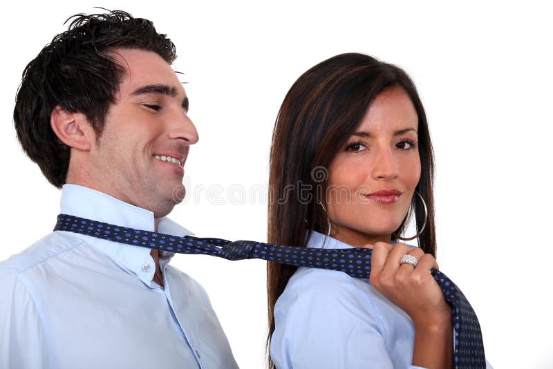 Woman leading a men by his tie. Woman leading a men by his tie