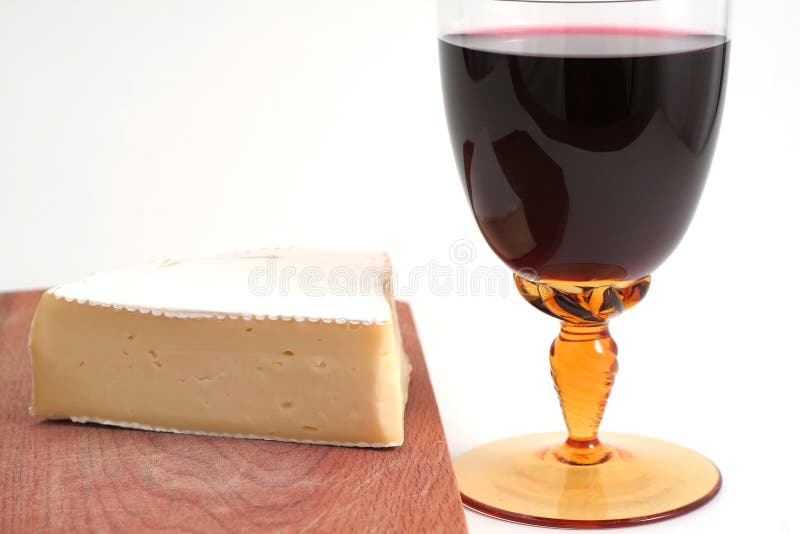 French cheese on wood trencher with red wine cup isolated on white. French cheese on wood trencher with red wine cup isolated on white
