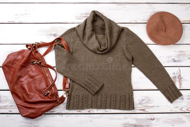 Flat lay female clothes and accessories. Women khaki color pullover and brown leather handbag. Ladies fashion style. Flat lay female clothes and accessories. Women khaki color pullover and brown leather handbag. Ladies fashion style.
