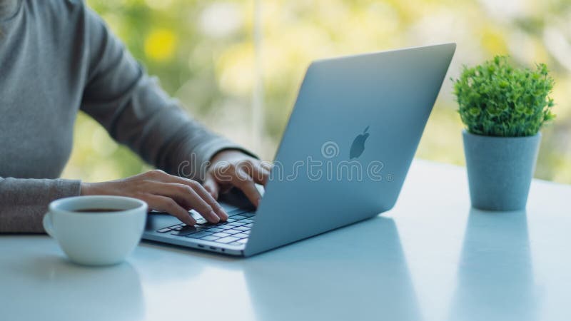 Jan 5th 2021 : A woman using and typing on Apple MacBook Pro laptop computer on the table in office, Chiang mai Thailand. Jan 5th 2021 : A woman using and typing on Apple MacBook Pro laptop computer on the table in office, Chiang mai Thailand