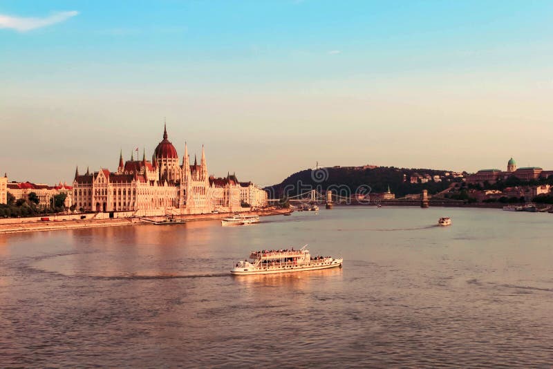 BUDAPEST, HUNGARY JULY 29, 2019: Beautiful evening view on Hungarian Parliament Building along Danube River with cruise ships on natural background. Text copy space. BUDAPEST, HUNGARY JULY 29, 2019: Beautiful evening view on Hungarian Parliament Building along Danube River with cruise ships on natural background. Text copy space