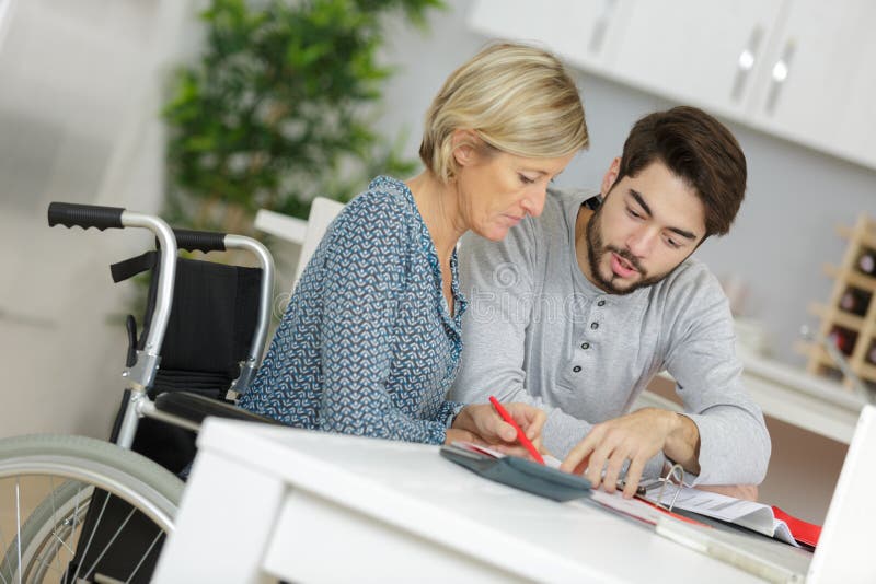 一位由年轻男子照顾的老妇人 免版税库存照片