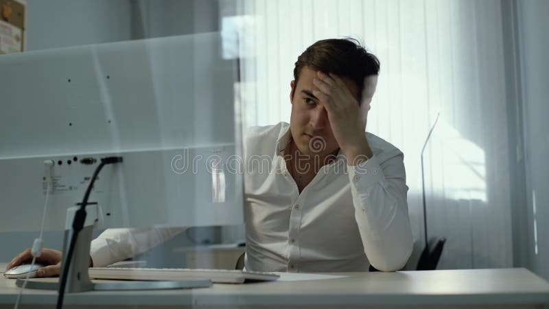 年轻办公室人工作者用手坐在计算机前面的头