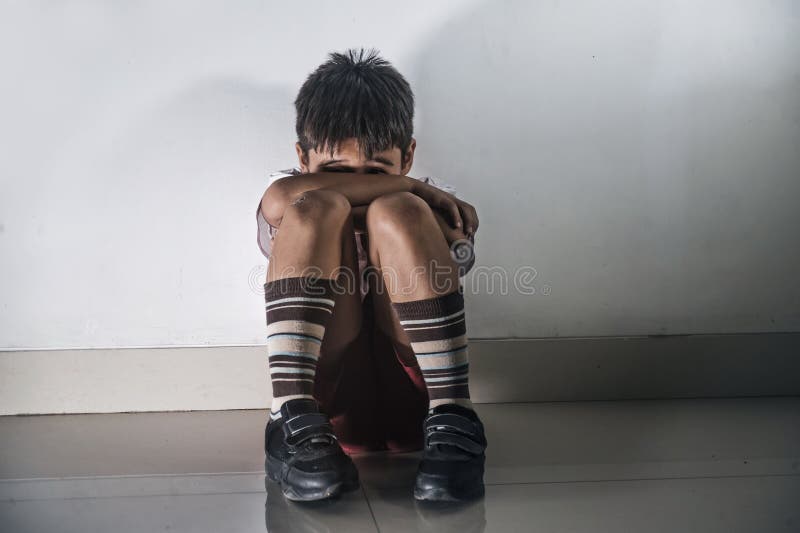 年轻哀伤和害怕的西班牙孩子和赞成害怕遭受的恶习的在校服坐哭泣单独降低的8岁 图库摄影 年轻哀伤和害怕的西班牙孩子和赞成害怕遭受的恶习的在校服坐哭泣单独降低的8岁 图库摄影