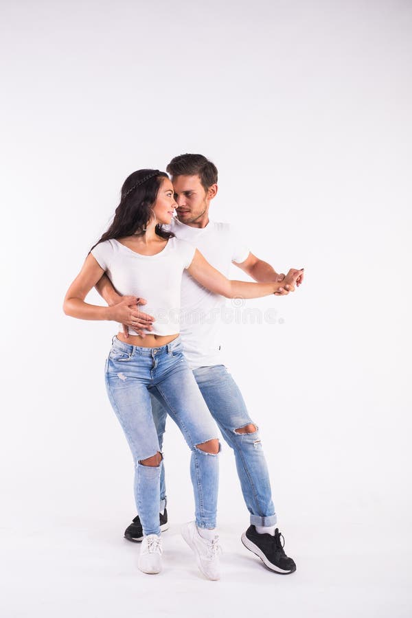Young couple dancing social latin dance bachata, merengue, salsa. Two elegance pose on white background. Young couple dancing social latin dance bachata, merengue, salsa. Two elegance pose on white background.