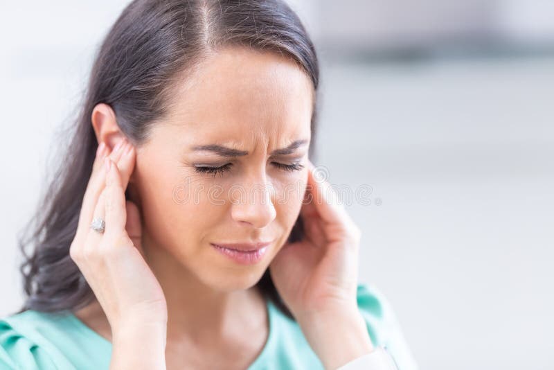 Young woman have headache migraine stress or tinnitus - noise whistling in her ears. Young woman have headache migraine stress or tinnitus - noise whistling in her ears