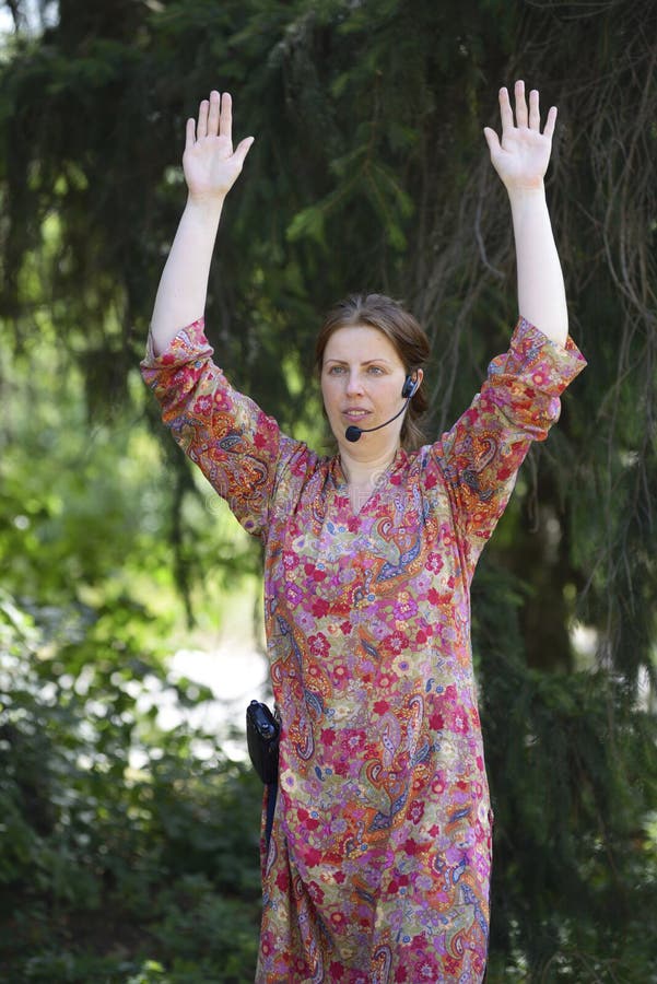 年轻女瑜伽教练展示在城市公园冥想的方式
