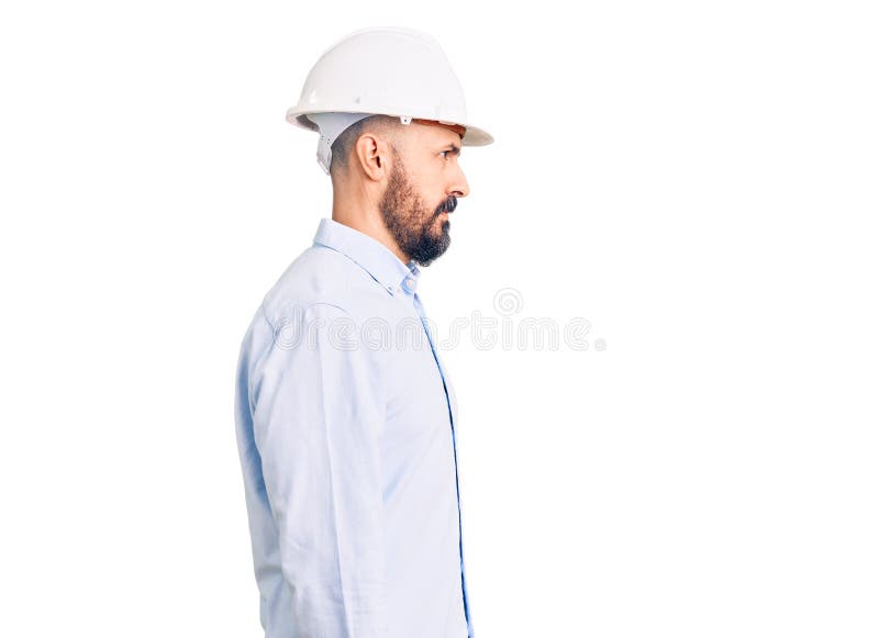 年轻帅气的男性，身着建筑师精装帽，面带自信的微笑，摆出一副自然的面孔 库存图片