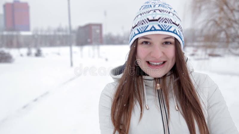 年轻快乐的女孩在冬天走在公园，使用在雪，寒冷