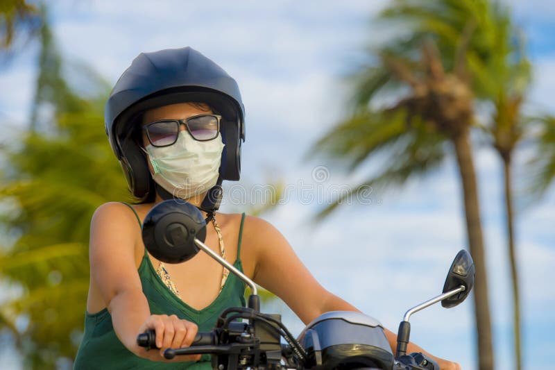 年轻愉快和相当亚洲中国妇女骑马滑行车佩带的摩托车盔甲和防护面罩在被赶走的摩托车保险柜 免版税库存图片 年轻愉快和相当亚洲中国妇女骑马滑行车佩带的摩托车盔甲和防护面罩在被赶走的摩托车保险柜 免版税库存图片